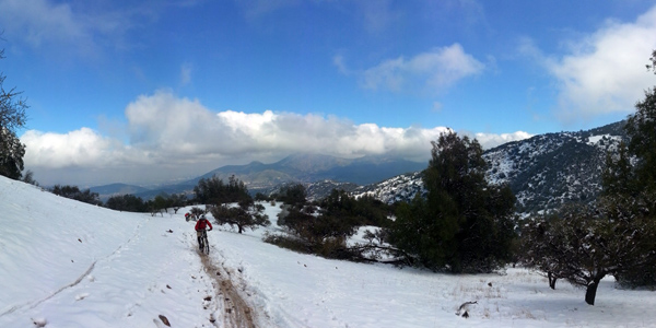 Fotografía de cerro nevado con ciclista subiendo y cerro manquehue a la distancia
